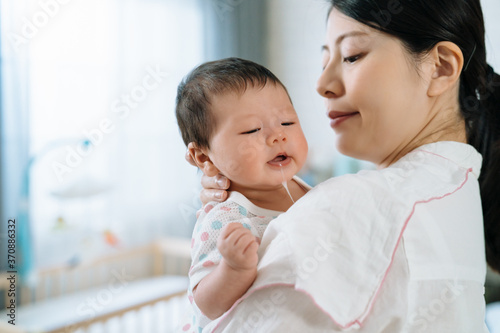 Canvastavla closeup japanese mother with cloth on shoulder is burping her child