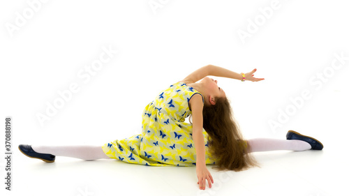 Girl Wearing Yellow Summer Dress and Shoes Sitting on Twine photo