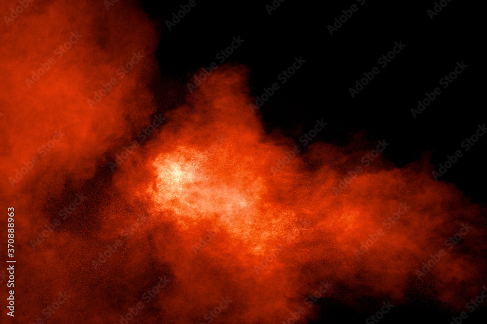 Abstract explosion of orange dust on black background.Freeze motion of orange powder burst.