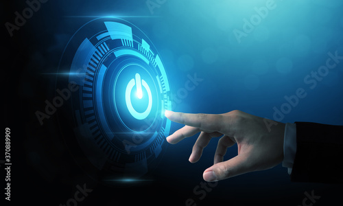 Hand of businessman pressing power button over computer. Start or shut down concept photo