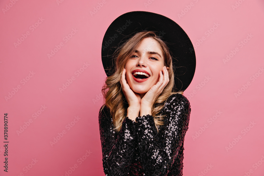 Gorgeous good-looking lady in black hat posing with excitement. Appealing white woman standing on pink background. Gorgeous good-looking lady in black hat posing with excitement. Appealing white woman standing on pink background.