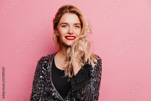 Laughing fascinating girl expressing happiness. Indoor photo of fashionable blonde lady standing on pink background.