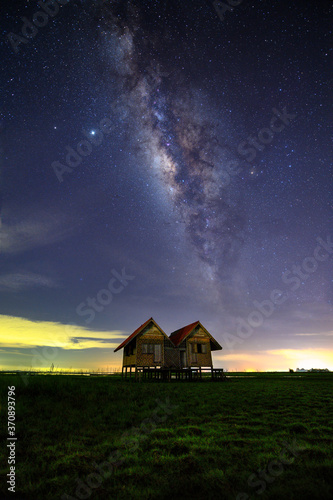 The old twin house near Chaloem Phra Kiat Bridge with milky way at Phatthalung Province, Thailand