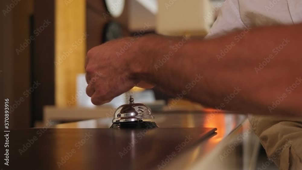 Close-up of a father with a young son pressing the bell at the hotel reception. Slow motion. Close-up of a father with a young son pressing the bell at the hotel reception. Slow motion.