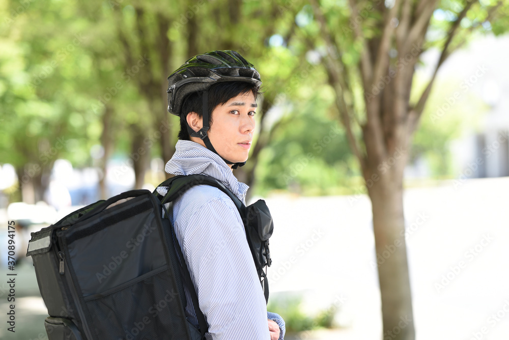 自転車で配達をするデリバリーの男性 自転車で配達をするデリバリーの男性
