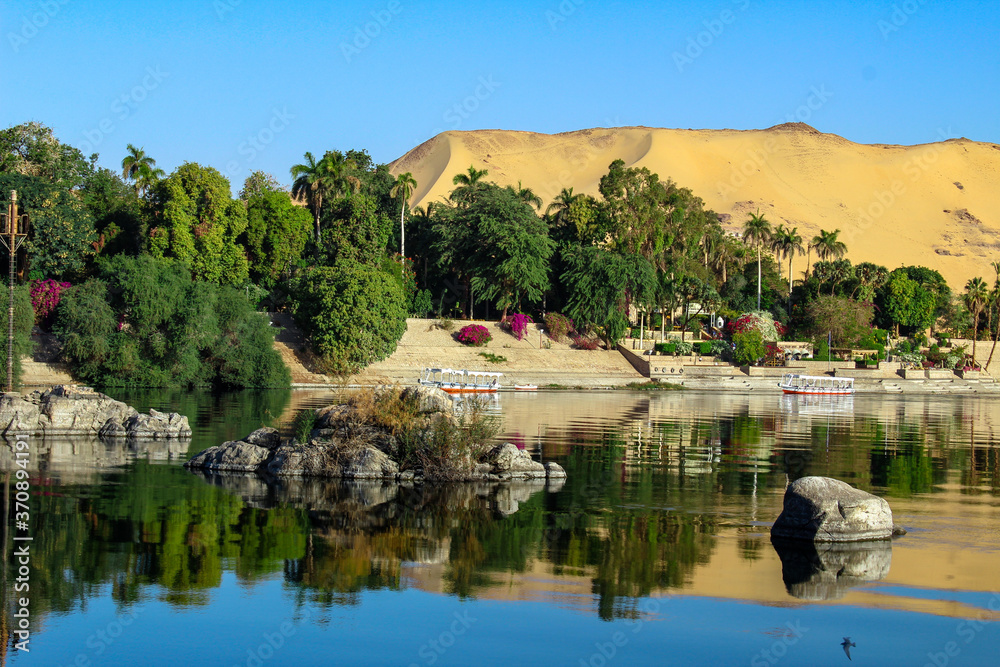 Elephantine Island on the bank of Nile River with the blue sky and plants in Aswan, Egypt.