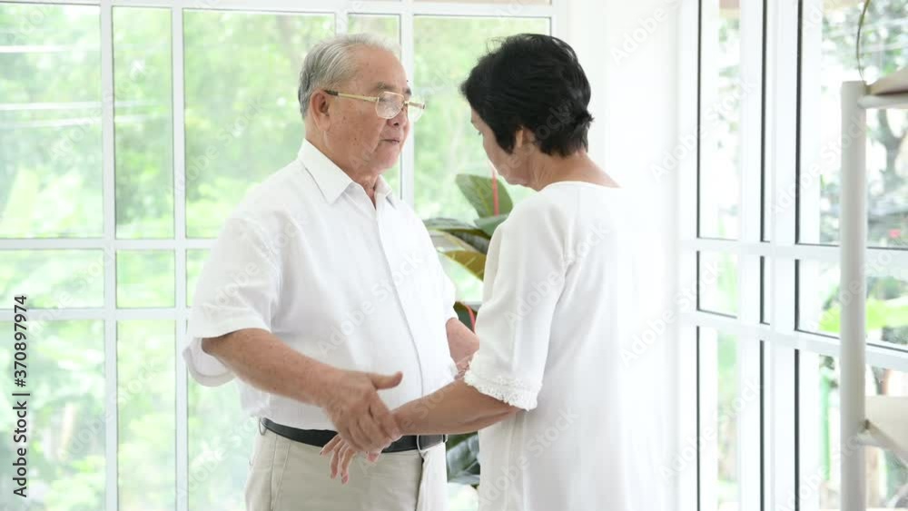 A senior elderly couple are hugging in home A senior elderly couple are hugging in home