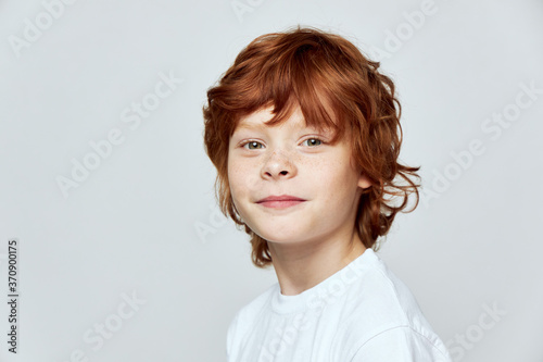 red-haired boy white t-shirt gray background studio close-up 