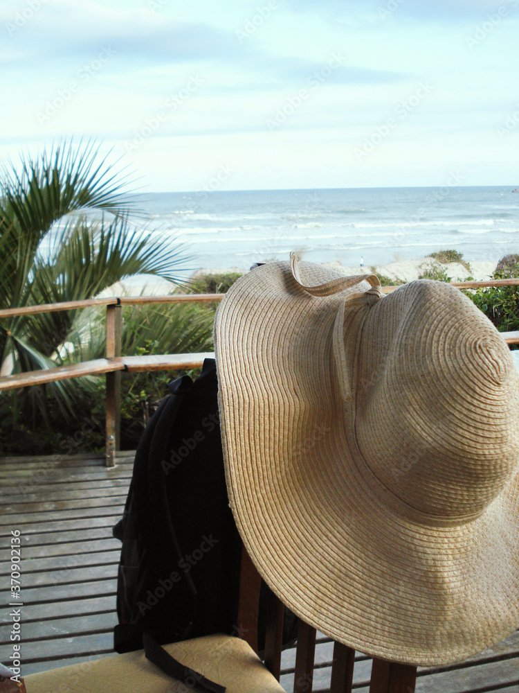 Woman's straw hat and sea in the background in Praia do Rosa, Florianopolis, Brazil