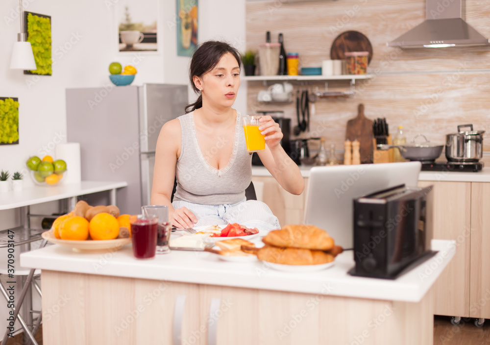 Woman making online shopping in the morning during breakfast paying with credit card. Entering information, customer using e-commerce technology buying stuff on the web, cosumerism banking and