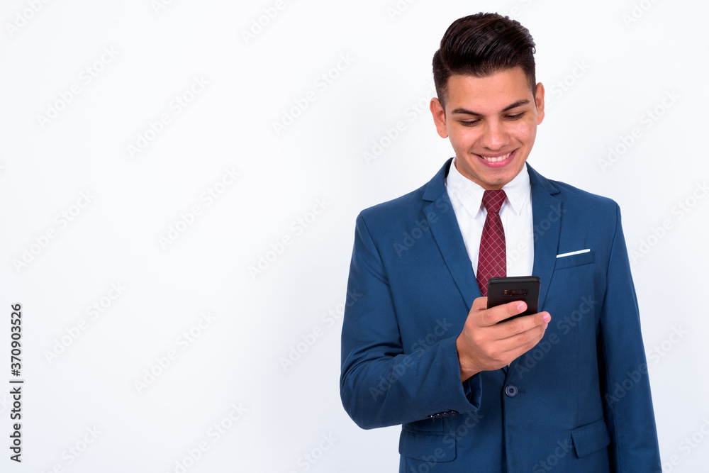 Portrait of happy young handsome multi ethnic businessman in suit using phone Portrait of happy young handsome multi ethnic businessman in suit using phone