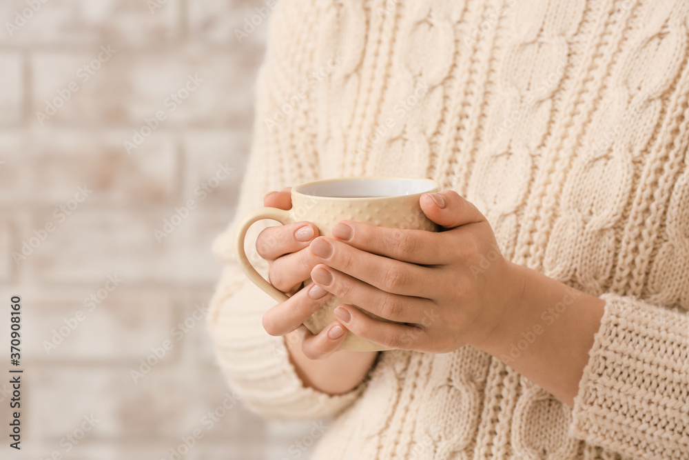 Woman with cup of hot tea at home, closeup