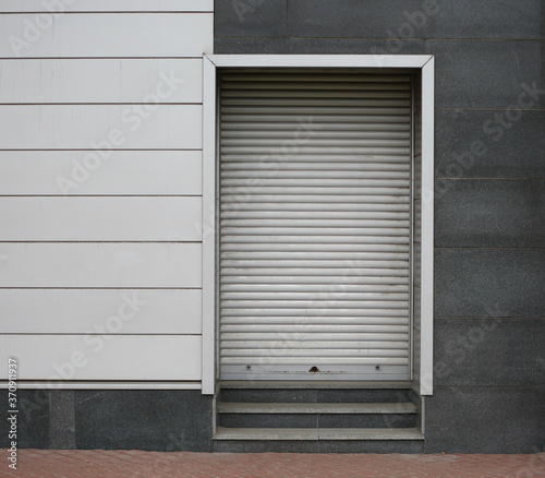 Closed metal roller shutter entrance to the modern building