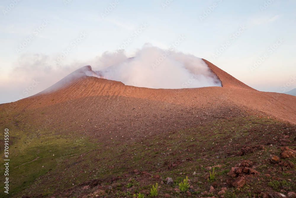 scenic panorama of the active volcano Telica with the first light of dawn and sulfuric smoke rising from the volcanic cone