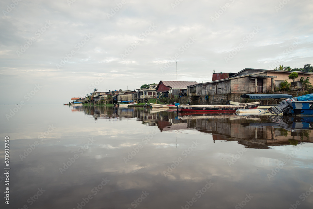 houses and pier reflected in the calm waters of the San Juan de Nicaragua River that borders Nicaragua and Costa Rica houses and pier reflected in the calm waters of the San Juan de Nicaragua River that borders Nicaragua and Costa Rica