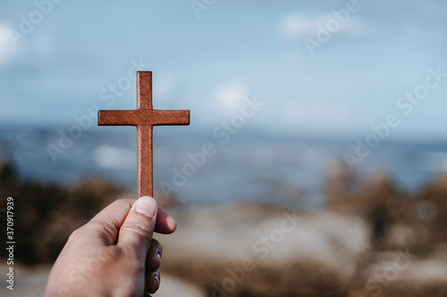 Man holding wooden cross. Concept hope divine pray freedom.