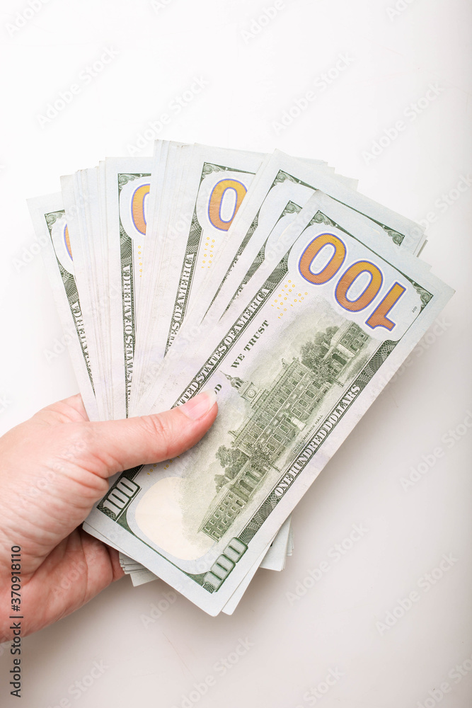Stack of one hundred dollar bills in hand Stack of one hundred dollar bills in hand
