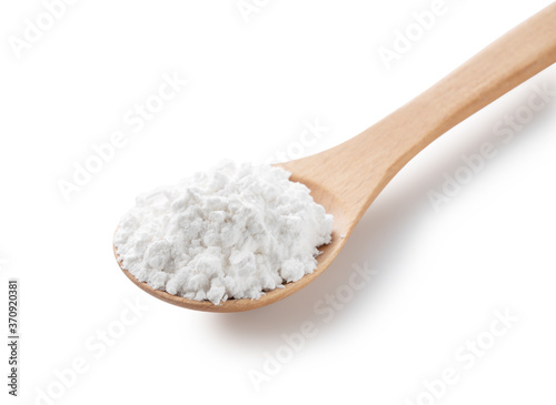 A wooden spoon and potato starch on a white background