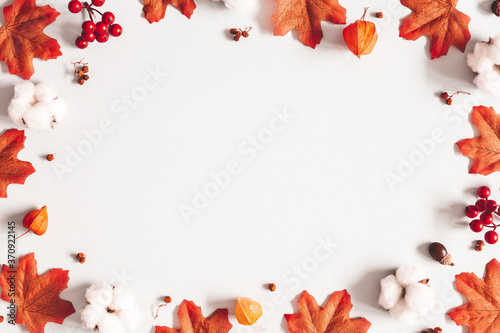 Autumn composition. Frame made of flowers, maple leaves on gray background. Autumn, fall, thanksgiving day concept. Flat lay, top view