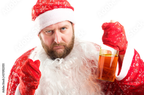 tired santa claus with no false beard raised the bottle of alcohol warningly photo