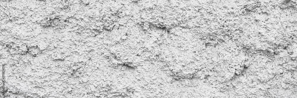 The texture of the gray wall. Decorative plaster. Rough grainy bumpy surface. Wide panoramic texture for background and design. The texture of the gray wall. Decorative plaster. Rough grainy bumpy surface. Wide panoramic texture for background and design.