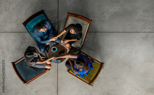 North African businesspeople shaking hands together in an office lounge photo