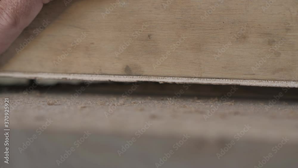 Close-up. A Joinery cuts an old walnut wood plank with an electric hand-held fraser