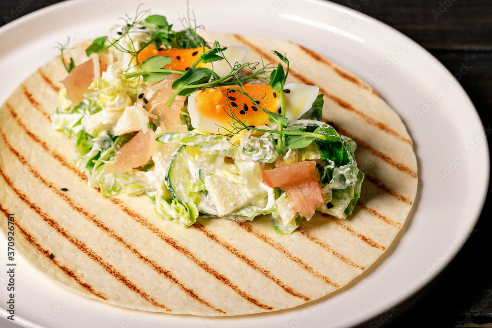 Close-up pita with fresh vegetable salad, smoked chicken, egg, herbs and black sesame seeds. Restaurant salad recipe Close-up pita with fresh vegetable salad, smoked chicken, egg, herbs and black sesame seeds. Restaurant salad recipe