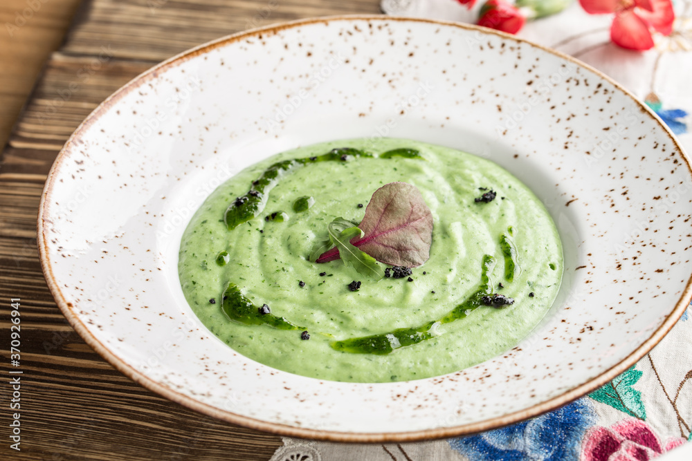 summer healthy green spinach soup on white plate on wooden table summer healthy green spinach soup on white plate on wooden table
