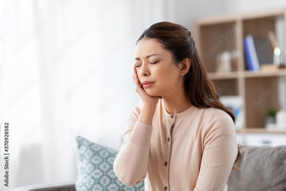 healthcare, dental health and problem concept - unhappy asian woman suffering from toothache at home healthcare, dental health and problem concept - unhappy asian woman suffering from toothache at home