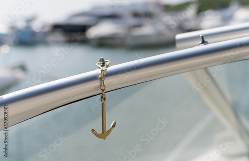 sea Golden anchor on the background of blured yachts in the sea in the sun