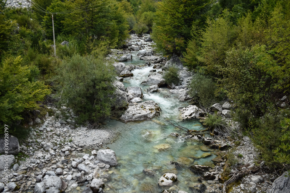 scenic mountainous landscape with stony river with clear blue waters in Valbone nature park