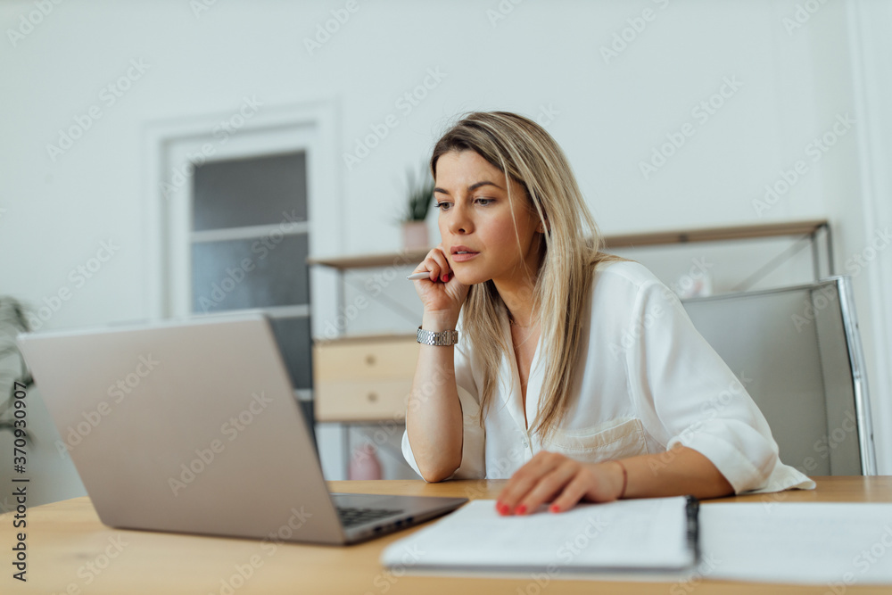 Beautiful concentrated woman reading something on laptop. Beautiful concentrated woman reading something on laptop.