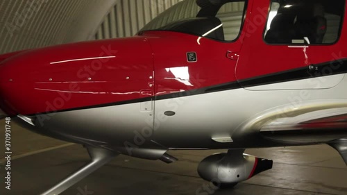 Red, small, shiny, areoplane in a hangar