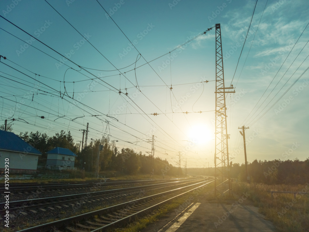 Landscape with railroad tracks in the rays of sunset Landscape with railroad tracks in the rays of sunset
