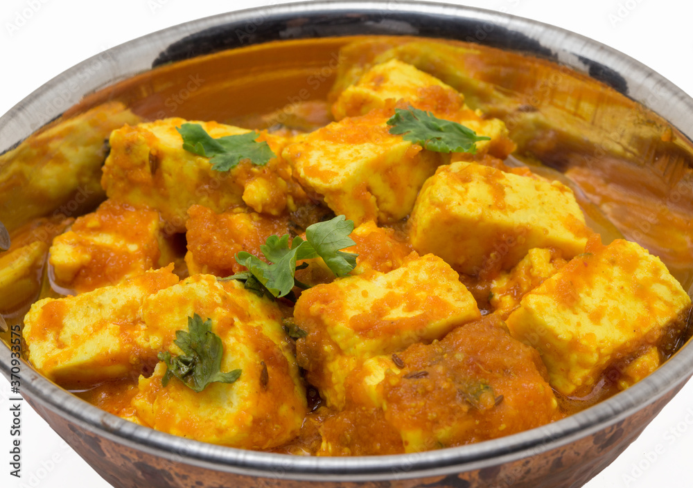 Home made recepie of kadahi paneer or paneer butter masala served in a brass bowl isolated on white available with clipping mask Home made recepie of kadahi paneer or paneer butter masala served in a brass bowl isolated on white available with clipping mask