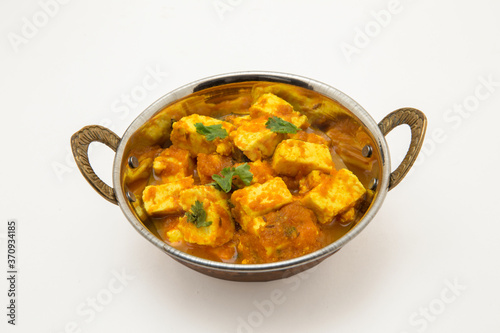 Home made recepie of kadahi paneer or paneer butter masala served in a brass bowl isolated on white available with clipping mask