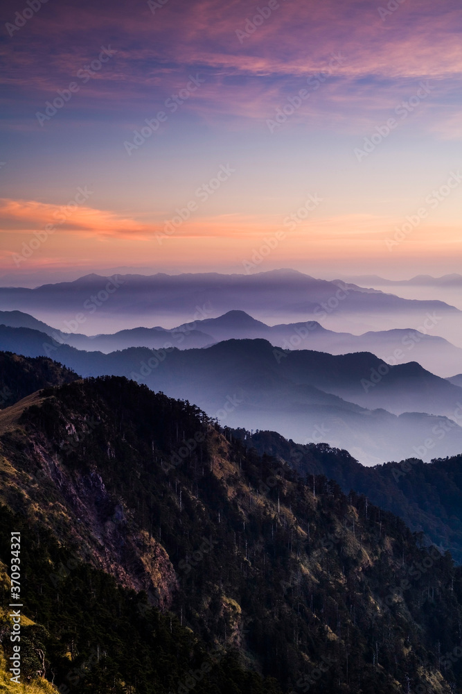 Layers of magnificent mountains at sunset with colorful clouds background. Hehuan Mountain in Taiwan, Asia. Taiwan Central Mountain Range.