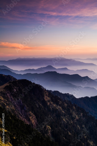 Layers of magnificent mountains at sunset with colorful clouds background. Hehuan Mountain in Taiwan, Asia. Taiwan Central Mountain Range. © BINGJHEN