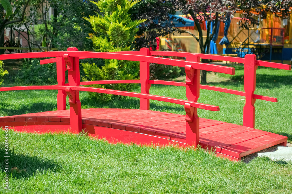 Wooden red bridge on green grass background Wooden red bridge on green grass background
