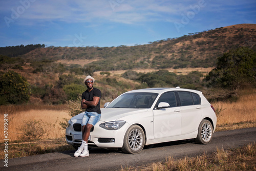 Successful black man with luxury car in the african safari photo
