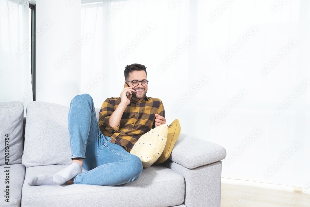 Happy man talking on mobile phone at home