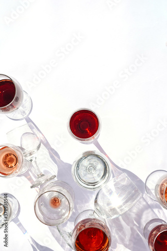 Glasses with red, white and rose wine on a white background.