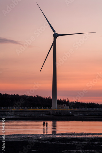 sunset view of Gaomei wetlands landscape and the wind power plant in Taichung, Taiwan. energy systems and renewable energy. © BINGJHEN