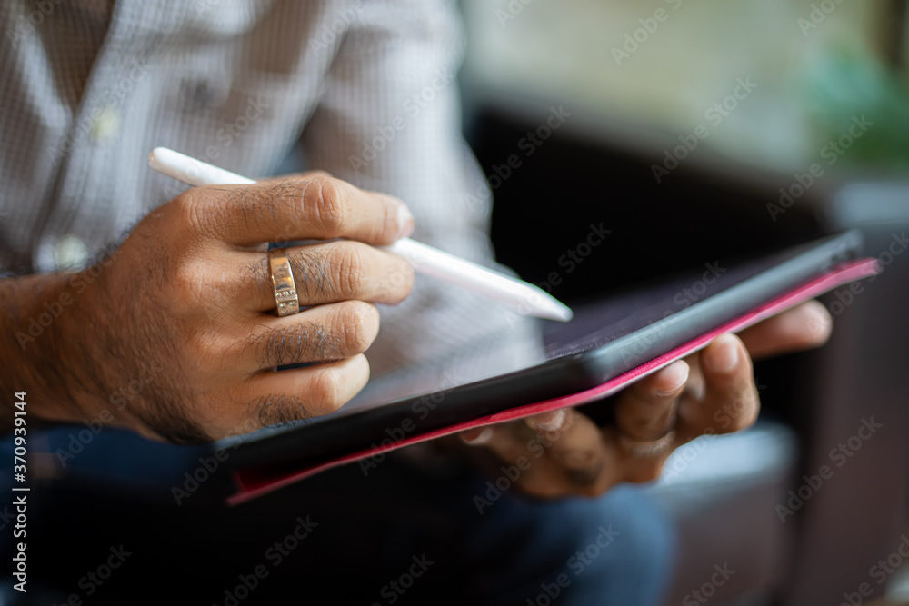 Asian business men using a tablet for working at coffee shop Asian business men using a tablet for working at coffee shop