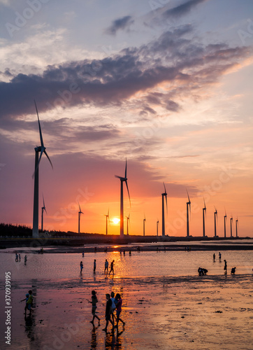 sunset view of Gaomei wetlands landscape and the wind power plant in Taichung, Taiwan. energy systems and renewable energy. photo