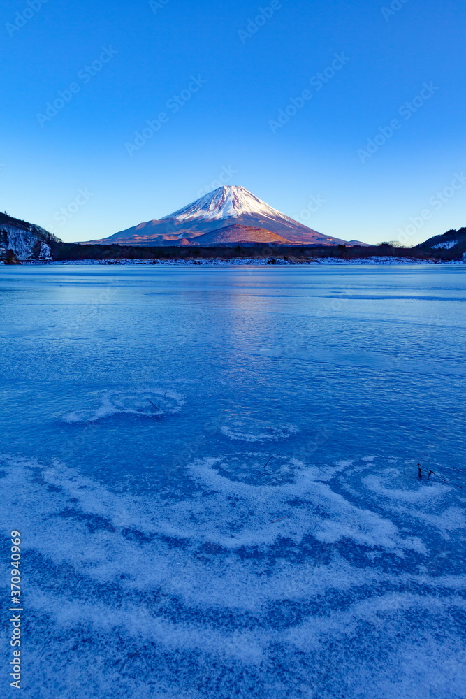 夕日を浴びた富士山と全面氷結した精進湖、山梨県富士河口湖町にて