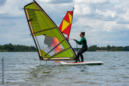 Woman learning windsurfing on a lake