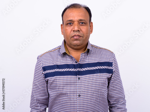 Portrait of mature overweight Indian businessman against white background