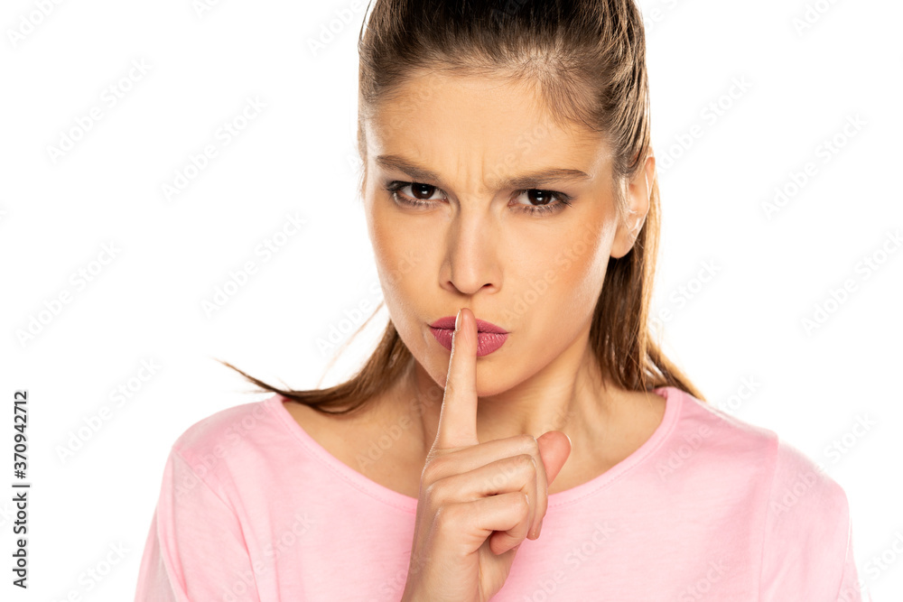 Young angry woman with finger on her lips Young angry woman with finger on her lips